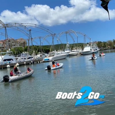 a group of people riding on the back of a boat in the water