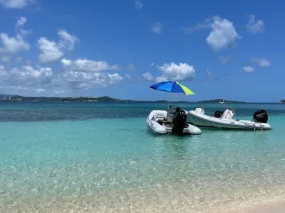 a boat sitting on top of a sandy beach next to the ocean